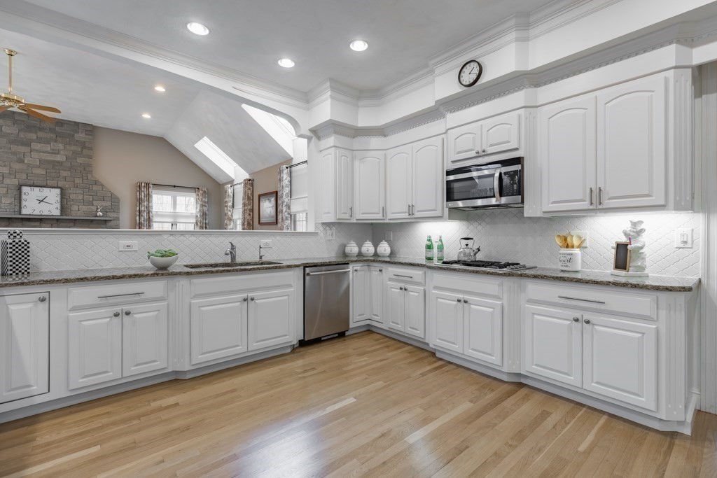 4 Walker Lane Boxford, MA 01921 - Photo 17 of 40 a kitchen with granite countertop white cabinets a sink and dishwasher with wooden floor