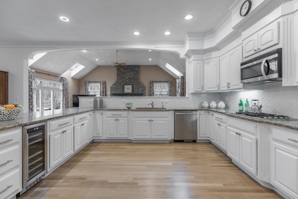 4 Walker Lane Boxford, MA 01921 - Photo 18 of 40 a large kitchen with stainless steel appliances granite countertop a large stove top oven a sink dishwasher and white cabinets with wooden floor