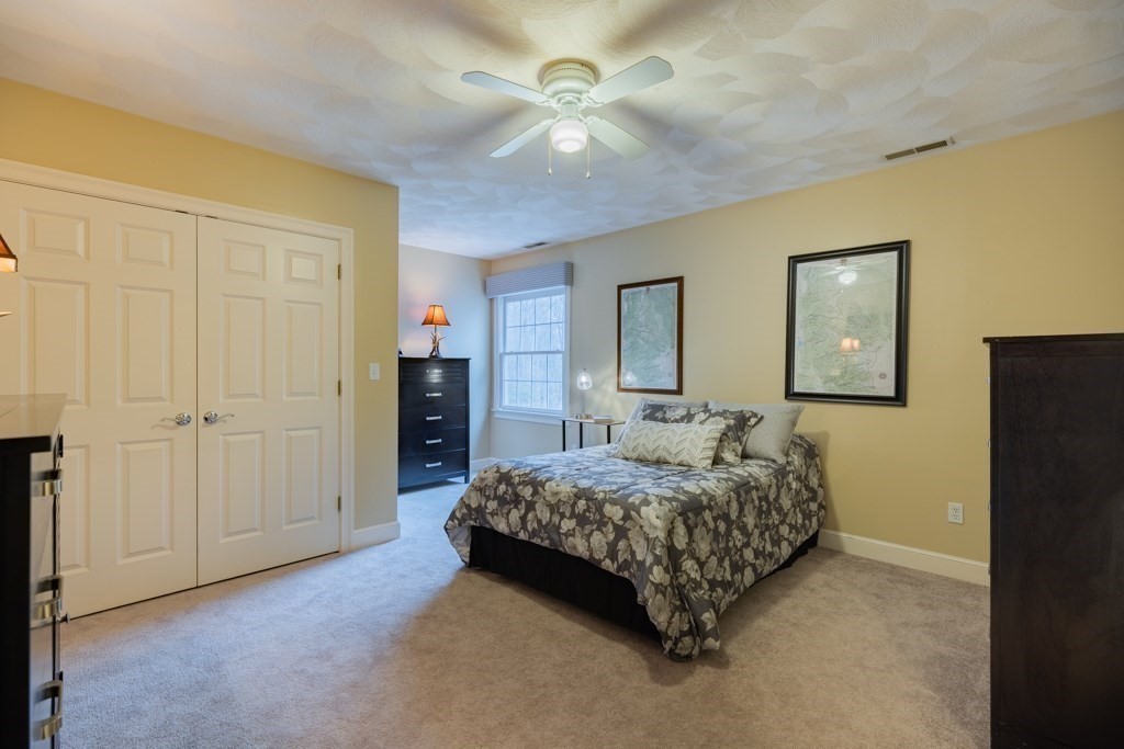 4 Walker Lane Boxford, MA 01921 - Photo 29 of 40 a bedroom with a bed and a chandelier