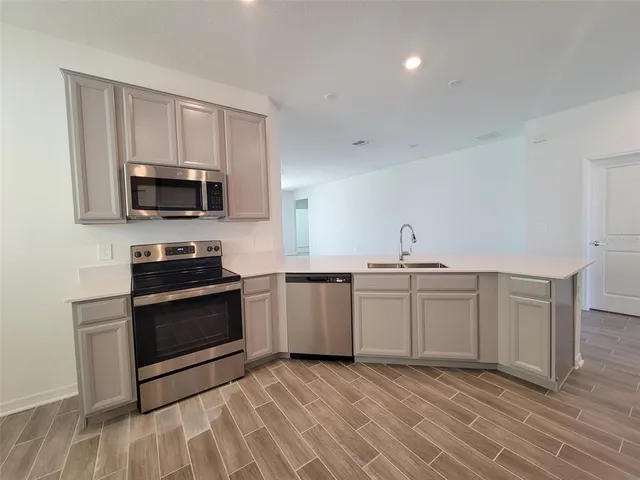 a kitchen with a refrigerator sink and cabinets