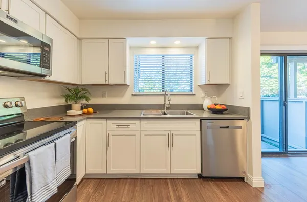 a kitchen with granite countertop white cabinets and white appliances