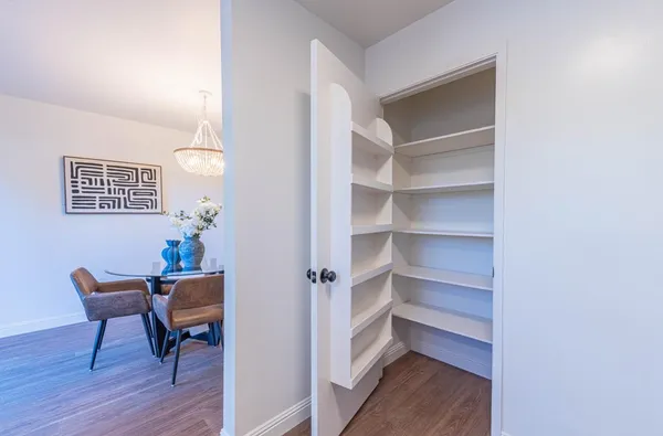 a view of a hallway with wooden floor and a workspace