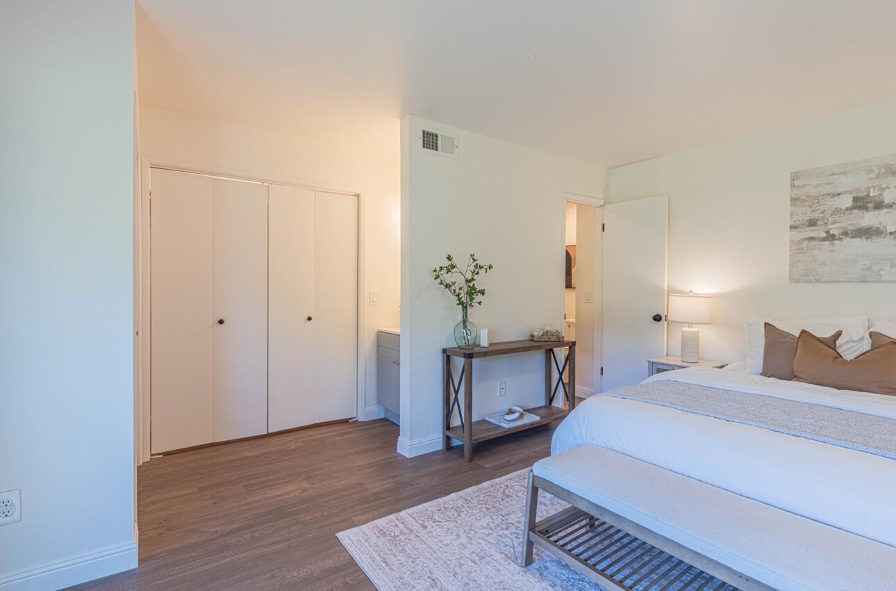 3850 Rio Road, Unit 24 Carmel, CA 93923 - Photo 27 of 39 a bedroom with a bed and wooden floor