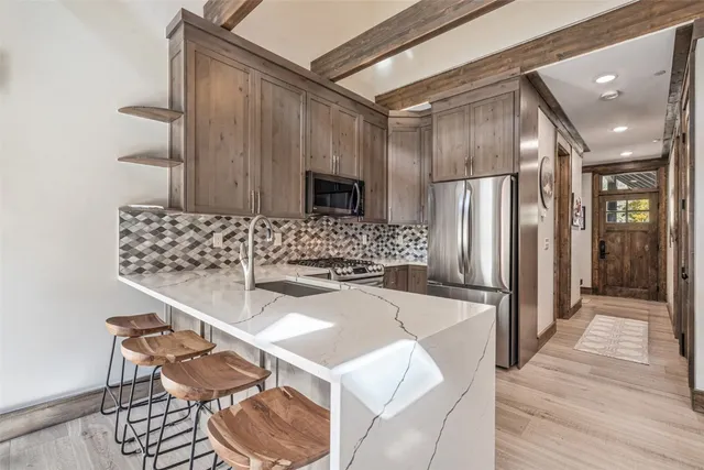 a kitchen with stainless steel appliances granite countertop a sink and a refrigerator