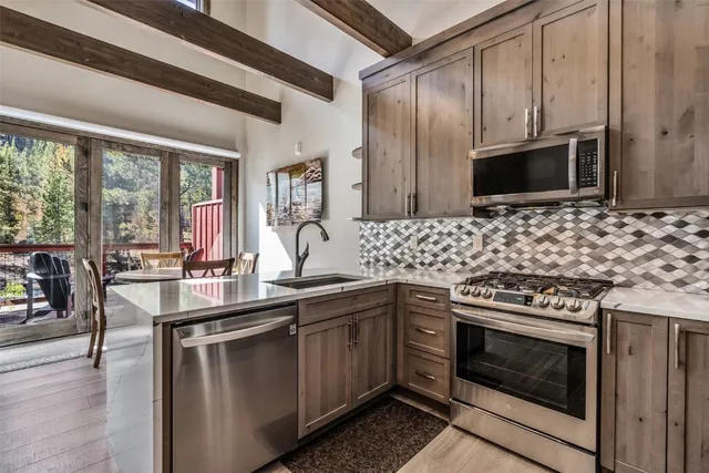 a kitchen with stainless steel appliances a stove sink and microwave