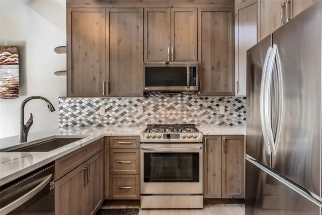 a kitchen with stainless steel appliances wooden cabinets sink and stove