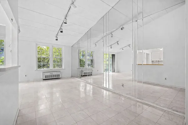 an empty room with kitchen and windows