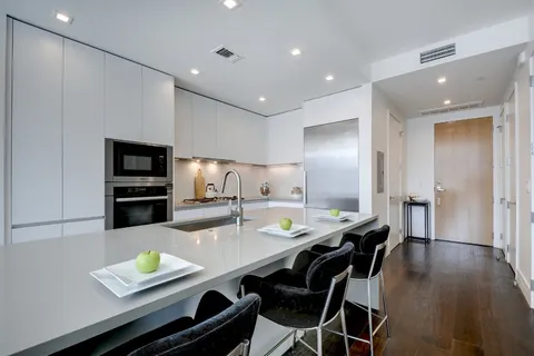 a kitchen with a dining table chairs and refrigerator