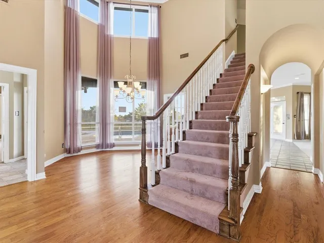 a view of staircase with wooden floor and a chandelier