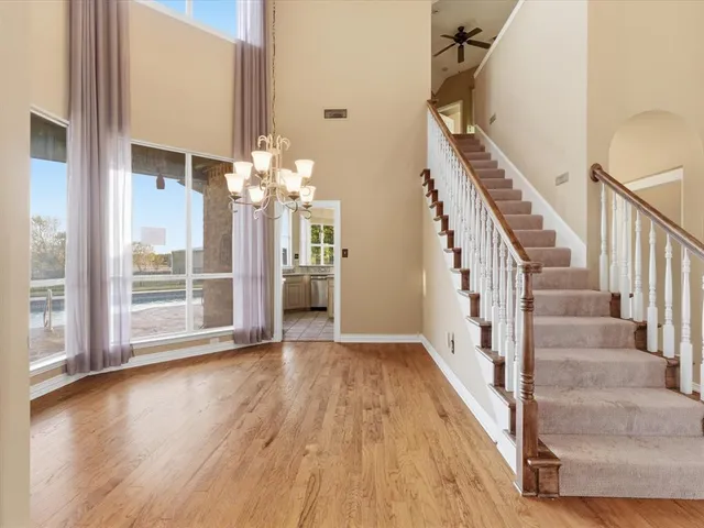 a view of a livingroom with wooden floor and stairs