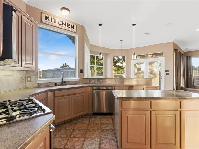 a kitchen with stainless steel appliances granite countertop a stove a sink and a refrigerator