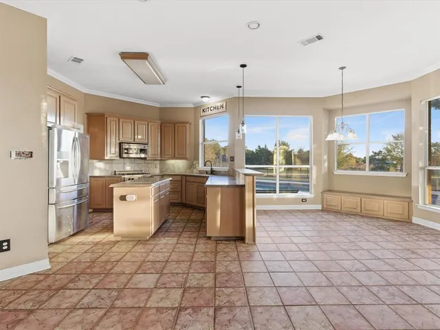 a kitchen with stainless steel appliances a stove a sink dishwasher a refrigerator and cabinets