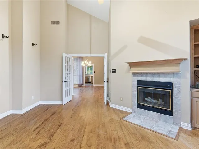 a view of a livingroom with wooden floor and a fireplace