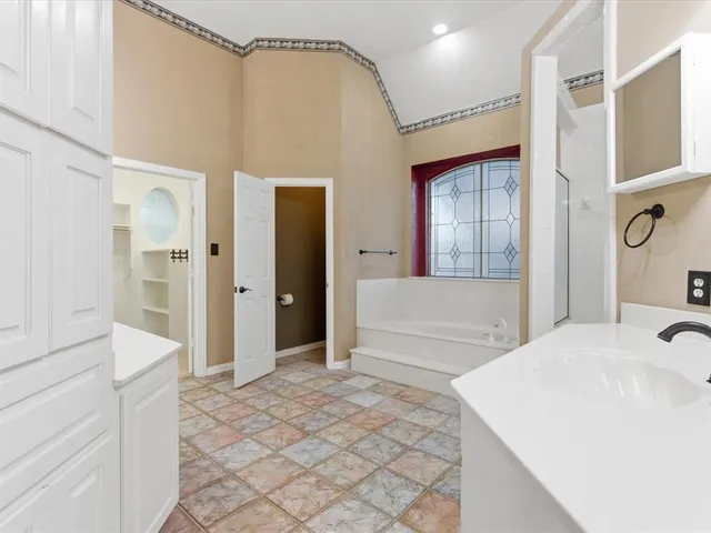a spacious bathroom with a sink and a mirror