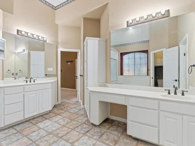a spacious bathroom with a double vanity sink mirror and a bathtub