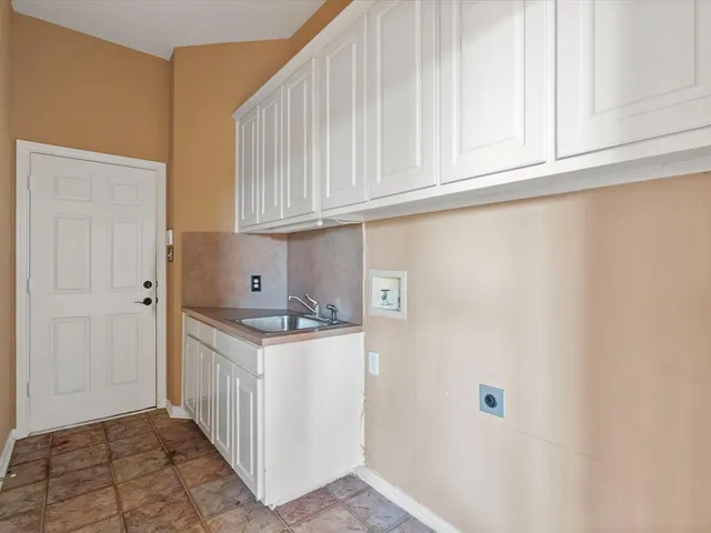 a kitchen with white cabinets and sink
