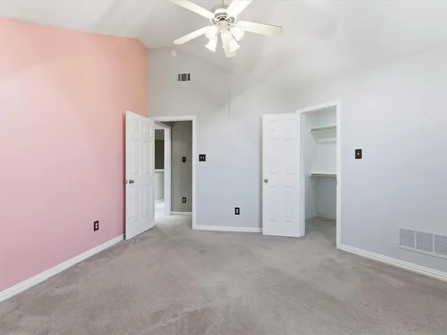 an empty room with fan and entrance