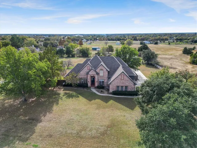 an aerial view of residential houses with outdoor space and ocean view