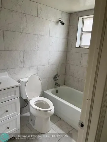 a white toilet sitting next to a bath tub