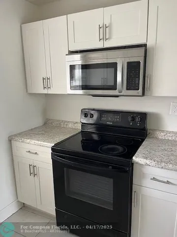 a kitchen with stainless steel appliances granite countertop a stove microwave and oven