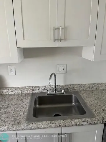 a kitchen with granite countertop a sink and a stove