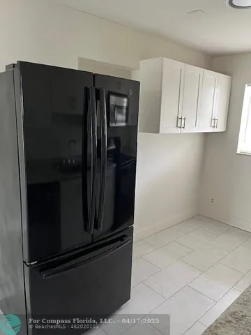 a view of kitchen cabinets and refrigerator