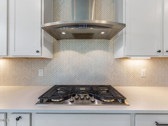 a large white kitchen with wooden floors and white walls