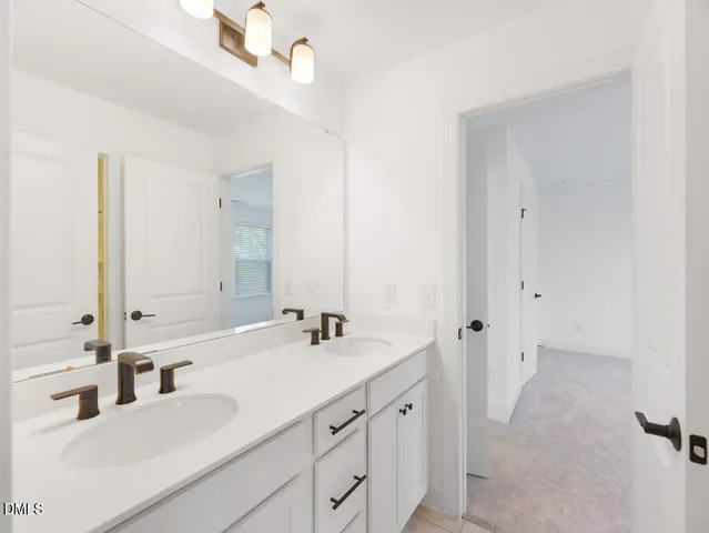 a bathroom with double vanity sink and a mirror
