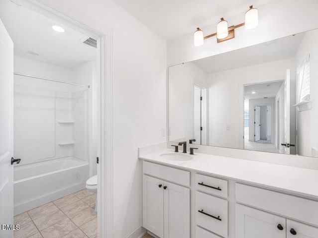 a bathroom with a tub a sink and mirror