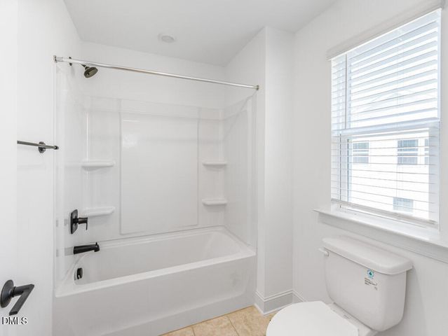 a white bath tub sitting next to a white toilet and a shower