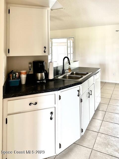 1040 Wing Road Southwest Palm Bay, FL 32908 - Photo 12 of 52 a kitchen with a sink a stove and white cabinets
