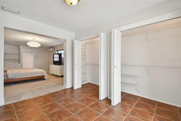 a spacious bedroom with a bed and a large mirror