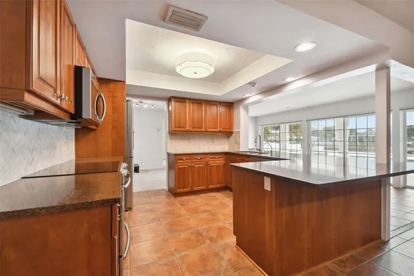 a kitchen with stainless steel appliances a stove microwave and sink
