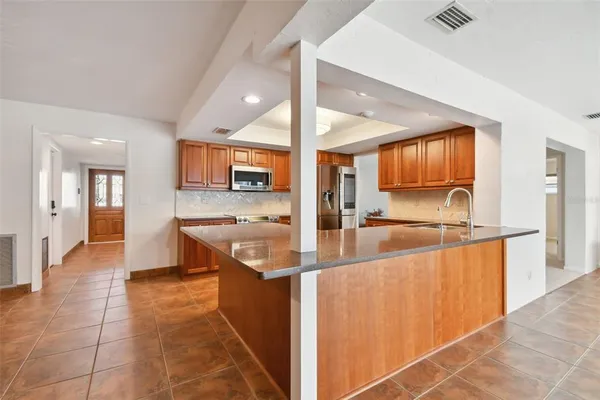 a large kitchen with a large window a sink and a counter top space