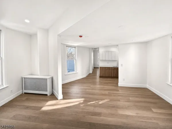 a view of empty room with wooden floor and window