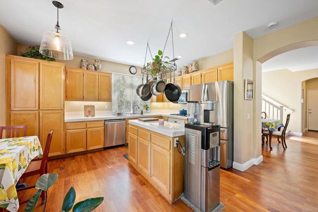 a kitchen with a sink appliances and wooden floor