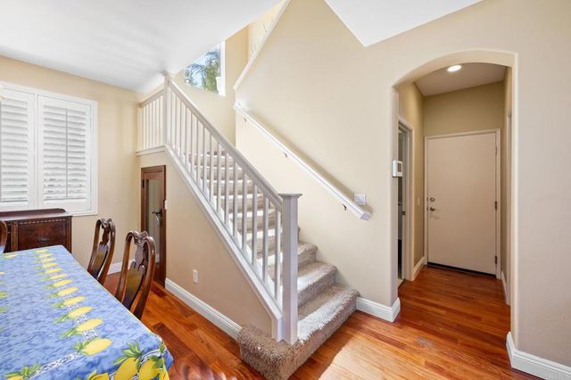 a view of a hallway with wooden floor and stairs