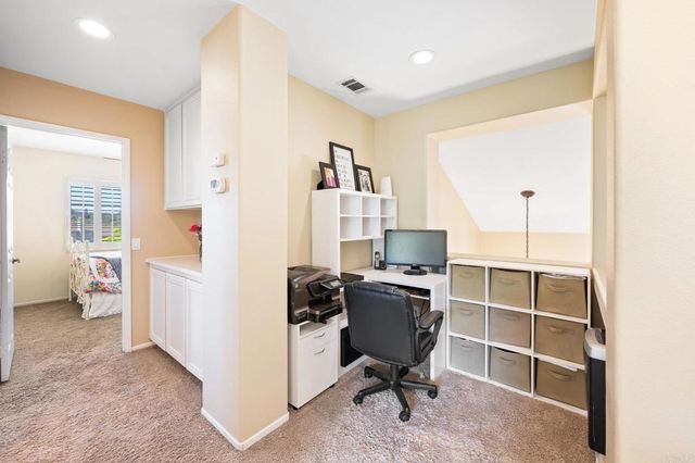 a view of a workspace with furniture and a window