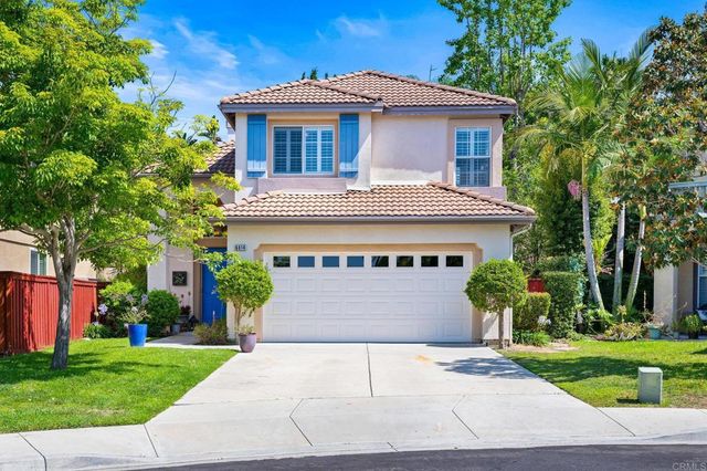 a front view of a house with a yard and potted plants