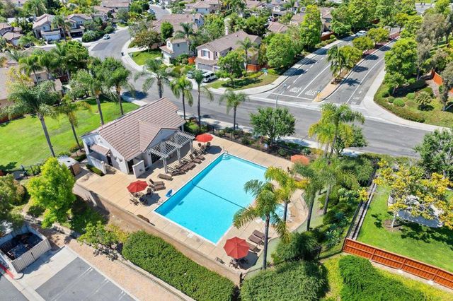 an aerial view of a house with swimming pool patio and lake view