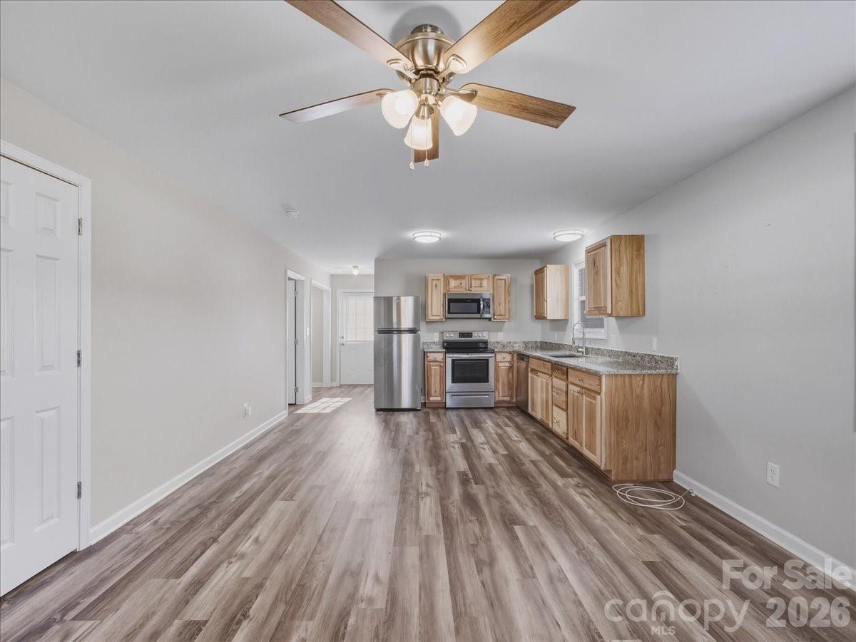 200 Blacksnake Road Stanley, NC 28164 - Photo 6 of 24 a view of a kitchen with a sink and dishwasher a refrigerator with wooden floor