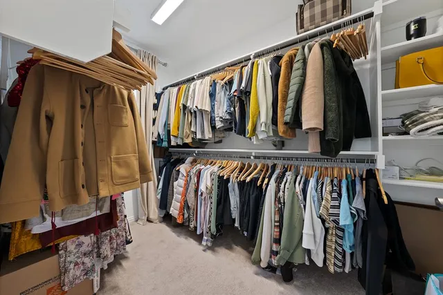 a view of walk in closet with clothes and shoes