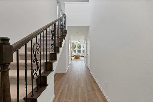 a view of a hallway with wooden floor and staircase