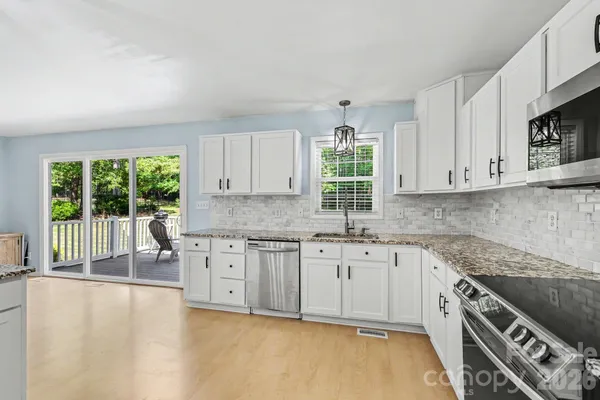a kitchen with granite countertop a stove a sink and a cabinets