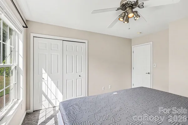 a view of a bedroom with a bed and a chandelier fan