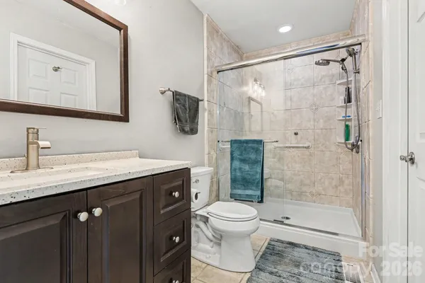 a bathroom with a granite countertop sink toilet and shower