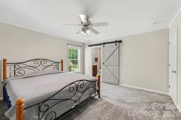 a bedroom with a bed and a ceiling fan