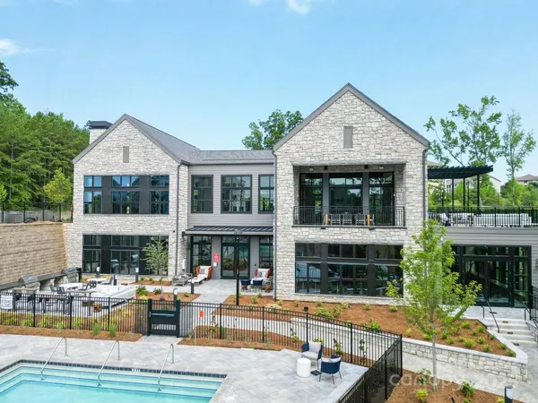 a view of house with swimming pool and outdoor seating