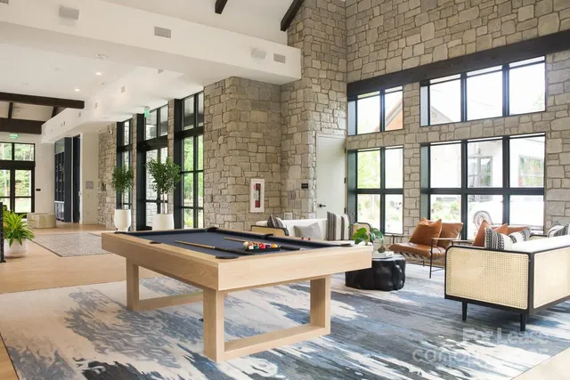 a living room filled with furniture and large windows