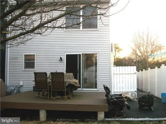 a view of backyard with seating space and trees in the background
